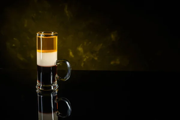 B-52 cocktail shot sobre superficie de espejo negro y fondo de pared oscuro — Foto de Stock