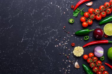 Sağlıklı Vegan gıda pişirme kavramı. Seçilmiş sebzeler, meyveler, baharatlar, siyah taş masada çeşitli soslar yapmak için otlar. Kopya alanı ile üst görünüm.