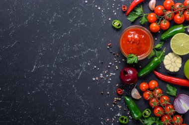 Koyu taş arka planda geleneksel Meksika salsa sosu ve malzemeler. Kopya alanı ile üst görünüm.