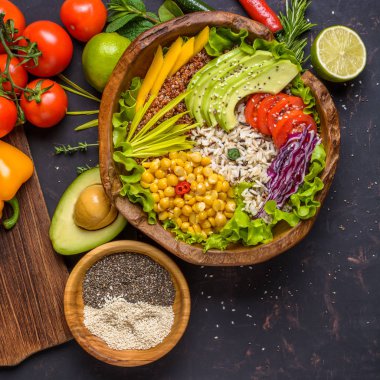 Nohut, avokado, yabani pirinç, Quinoa tohumu, biber, domates, yeşillik, lahana, eskipkoyu taş masa ve chia ve susam ile ahşap kase üzerinde marul ile Buda kase. Üstte görüntü.