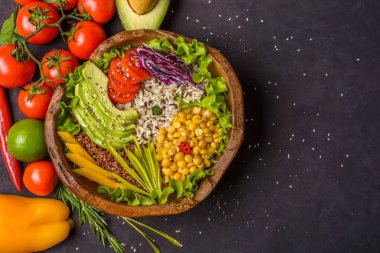 Nohut, avokado, yabani pirinç, kinoa, domates, yeşillik, lahana ve koyu taşlı marul içeren ahşap kâse. Vejetaryen süper yiyecekler. Kopyalama alanı olan üst görünüm.