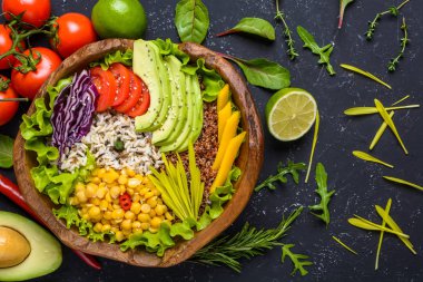 Quinoa, yabani pirinç, nohut, domates, avokado, yeşillik, lahana, siyah taş arka plan üst görünümünde marul ile Sağlıklı vegan superfood kase. Gıda ve sağlık