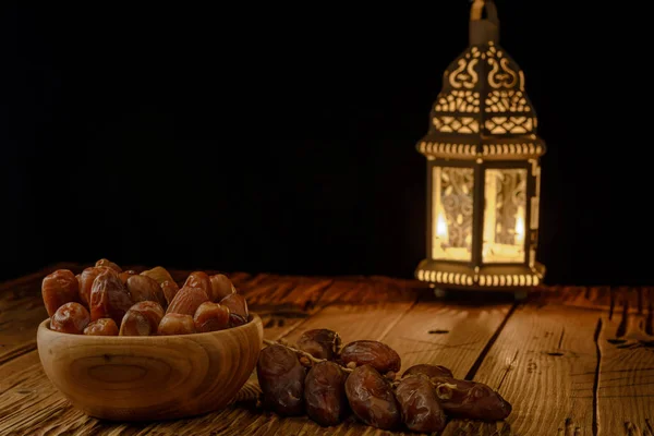 Date in ciotola di legno e lanterna su tavolo di legno. Mese santo musulmano Ramadan Kareem. Copia spazio . — Foto Stock