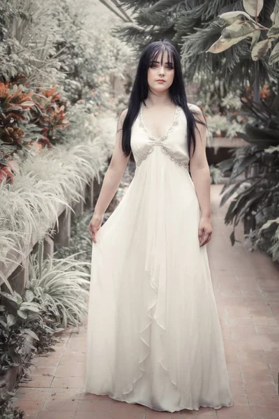 Uzun akan içinde güzel genç kadın elbise botanik bahçelerinde