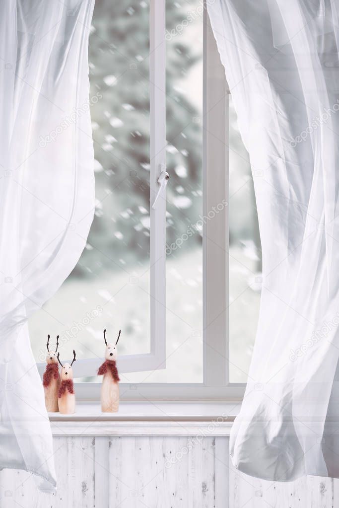 Wooden reindeers sitting in winter window