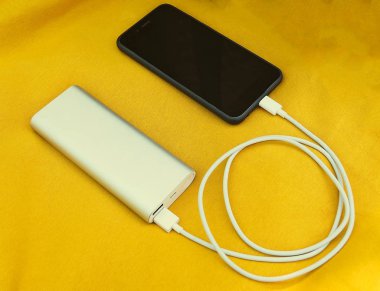 Güç banka ile sarı kumaş arka plan üzerinde iki usb.