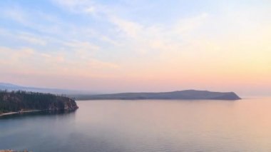 Rusya, Baykal Gölü, Olkhon Adası, küçük deniz Bay. Cape Ulan-Khushun. Cape Nyurgan görünümden. Günbatımı gecesine geçiş. Video. UltraHD (4k)