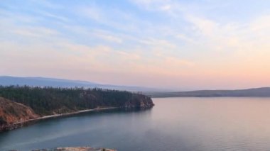 Rusya, Baykal Gölü, Olkhon Adası, küçük deniz Bay. Cape Ulan-Khushun. Cape Nyurgan görünümden. Günbatımı gecesine geçiş. Video. UltraHD (4k)