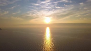 Rusya, Baykal Gölü, Olkhon Adası, Küçük Deniz Koyu üzerinde Günbatımı. Video kaydı. UltraHD (4K)