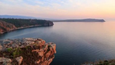 Rusya, Baykal Gölü, Olkhon Adası, küçük deniz Bay. Cape Ulan-Khushun. Cape Nyurgan görünümden. Günbatımı gecesine geçiş. Video. UltraHD (4k)
