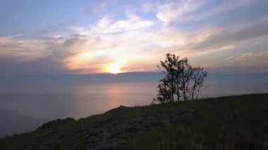 Rusya, Baykal Gölü, Olkhon Adası, Küçük Deniz Koyu üzerinde Günbatımı. Video kaydı. UltraHD (4K)