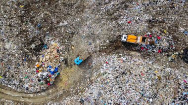 Garbage trucks unload garbage to a landfill in the vicinity of the city of Yekaterinburg, Russia, From Drone, HEAD OVER SHOT   clipart