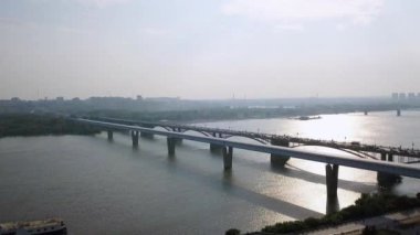 Metro Köprüsü ve Comal Köprüsü. Novosibirsk şehrinin panoraması. Ob nehrinin manzarası. - Rusya. Video kaydı. UltraHD (4K)