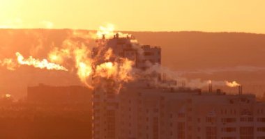 Borularda yüksek katlı konut binası, sabah erken, arkadan gelen duman. Telefoto lens. Serap atmosferde. Video. UltraHD (4k)