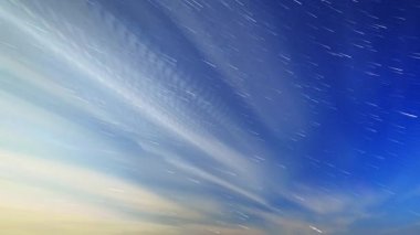 Bulutlar ve mehtaplı bir gecede yıldız. Ay çerçevede görüntülenir ve bu yanıp söner 