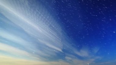 Bulutlar ve mehtaplı bir gecede yıldız. Ay çerçevede görüntülenir ve bu yanıp söner 