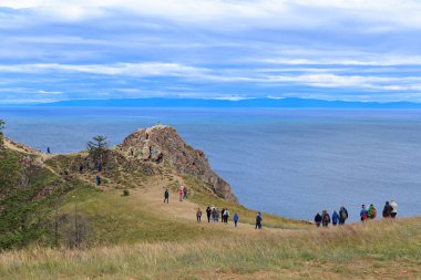Russia, Baikal, Olkhon. Tourists at Cape Shunte admire Lake Baikal clipart
