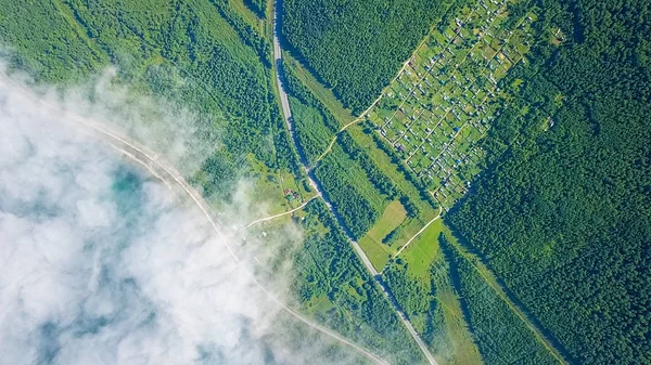 The train crawls along the railway under the clouds along the coast. Transibir railway. Highway. Flying above the clouds. Coast of Lake Baikal., From Drone, HEAD OVER SHOT