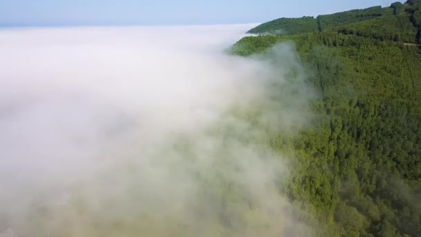 Voler au-dessus des nuages. Côte du lac Baïkal. Montagnes couvertes de forêt. La Russie. Vidéo. UltraHD (4K)