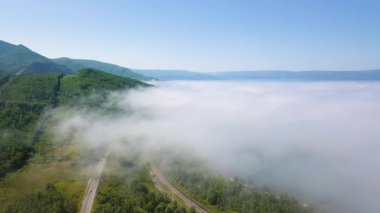 Bulutların üzerinde uçuyor. Baykal Gölü kıyısında. Ormanla kaplı dağlar. - Rusya. Video kaydı. UltraHD (4K)