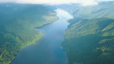 Teletskoye Gölü 'nün panoramik manzarası bulutlara tırmanıyor. Rusya, Altai. Ormanlarla kaplı dağlar. Video kaydı. UltraHD (4K)