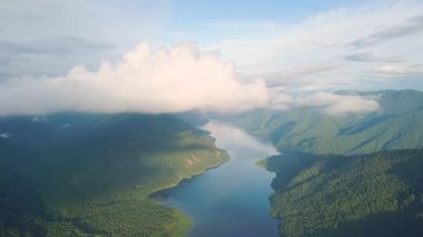 Teletskoye Gölü 'nün panoramik manzarası bulutlara tırmanıyor. Rusya, Altai. Ormanlarla kaplı dağlar. Video kaydı. UltraHD (4K)