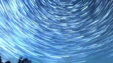 Starry gökyüzü kutup yıldızı etrafında döner. İzleri solma hatları şeklinde bırakın. Kış, Rusya. Video. UltraHD (4k)