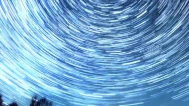 Starry gökyüzü kutup yıldızı etrafında döner. İzleri solma hatları şeklinde bırakın. Kış, Rusya. Video. UltraHD (4k)