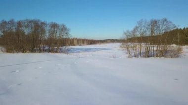 Kar üzerinde izleri ile uçan. Donmuş göl. Drone 'dan gölge. Kışın temiz hava. Video. UltraHD (4k)