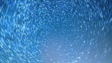 Yıldızlı gökyüzü kutup yıldızının etrafında döner. Çizgiler şeklinde izler bırakın. Kış, Rusya. Video. Ultrahd (4k))