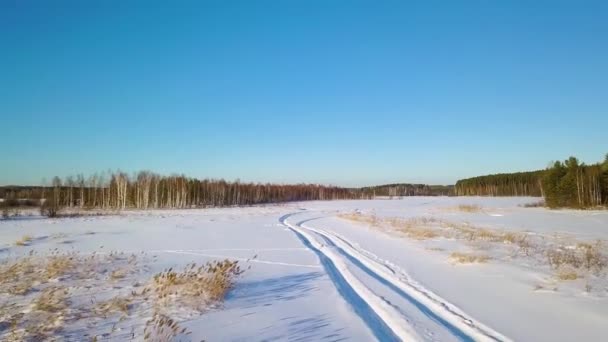 低飞行在雪与痕迹 冰冻的湖无人机上的阴影 冬季天气晴朗 Ultrahd — 图库视频影像