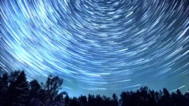Starry gökyüzü kutup yıldızı etrafında döner. İzleri solma hatları şeklinde bırakın. Kış, Rusya. Video. UltraHD (4k)
