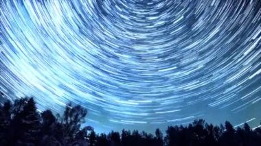 Starry gökyüzü kutup yıldızı etrafında döner. İzleri solma hatları şeklinde bırakın. Kış, Rusya. Video. UltraHD (4k)