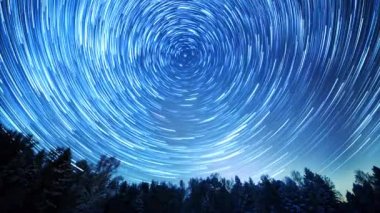 Starry gökyüzü kutup yıldızı etrafında döner. İzleri solma hatları şeklinde bırakın. Kış, Rusya. Video. UltraHD (4k)