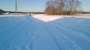 Karda dar bir yol üzerinde düşük uçan. Kışın temiz hava. Video. UltraHD (4k)