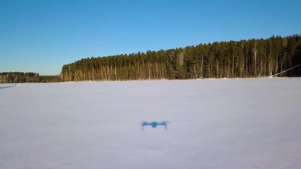 痕跡と雪の上に低い飛行 凍った湖だドローンからの影 冬の快晴 ビデオ Ultrahd — ストック動画