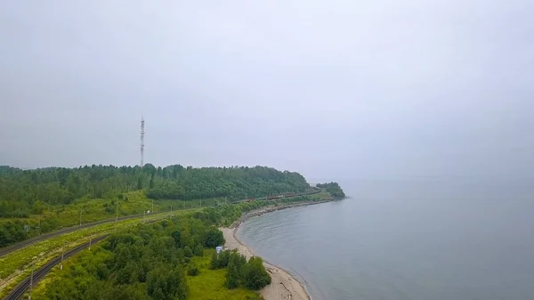 Ρωσία, Baikal - 02 Αυγούστου 2018: Trans-Siberian Railway, ακτή της λίμνης Baikal. Τρένο κίνηση κατά μήκος της ακτής της λίμνης, από Drone — Φωτογραφία Αρχείου