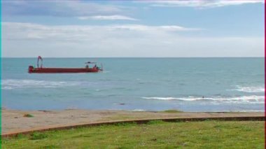 Aksaklık etkisi. Denizde kırmızı mavna. Ostia, Italya. Video