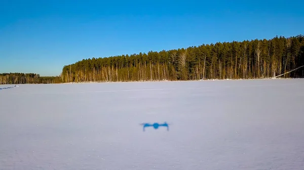 低飞行在雪上的痕迹。冰冻的湖。无人机的影子，机动。冬季晴朗的天气，从无人机 — 图库照片