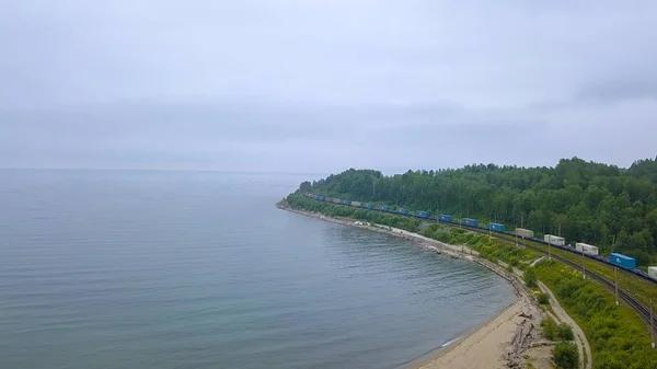 Ρωσία, Baikal - 02 Αυγούστου 2018: Trans-Siberian Railway, ακτή της λίμνης Baikal. Τρένο κίνηση κατά μήκος της ακτής της λίμνης, από Drone — Φωτογραφία Αρχείου