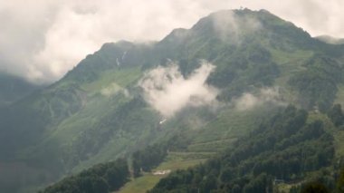 Aksaklık etkisi. Dağ yamacında bulutlar içinde. Spole, ne var? Timelapse. Rosa Khutor, Sochi, Rusya Federasyonu