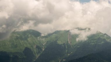 Aksaklık etkisi. Dağ yamacında bulutlar içinde. Timelapse. Ridge Aibga, Rosa Khutor, Sochi, Rusya Federasyonu