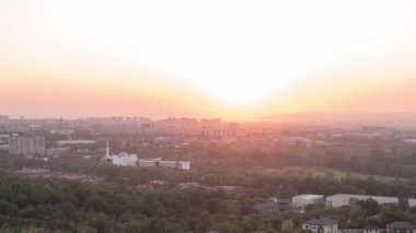 Aksaklık etkisi. Alma Ata şehri üzerinde günbatımı. Kazakistan. Zoom. Zaman atlamalı. Video. UltraHD (4k)