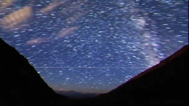 Aksaklık etkisi. Çizgiler şeklindeki yıldızlardan izler. Ay yükseliyor. Yayla Kara-Say (3.800 m.) Kırgızistan. Zaman Atlamalı. Video. Ultrahd (4k))