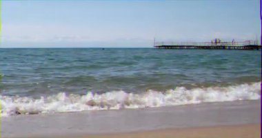 Aksaklık etkisi. Dağların arka planda Issyk-Kul gölünün suları, Cholpon Ata sahil kasabası. Issyk Kul, Kırgızistan. Video. Ultrahd (4k))