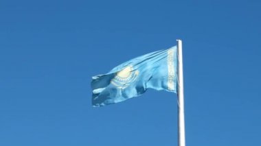 Aksaklık etkisi. Kazakistan Cumhuriyeti bayrağı arka plan mavi gökyüzünde sallayarak bayrak direği üzerinde. Video