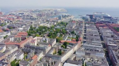 Kopenhag, Danimarka. Kopenhag limanındaki yolcu gemisi, şehir çatıları ve Kopenhag gölleri. Hava görüntüsü. 4K