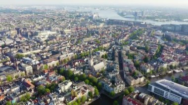 Amsterdam, Hollanda. Amsterdam Merkez İstasyonu (Amsterdam Centraal) doğru şehir çatıları üzerinde uçan. 4k