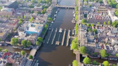 Amsterdam, Hollanda. Şehrin çatılarında uçuyor. Amstel Nehri, Amstel Geçidi. 4K