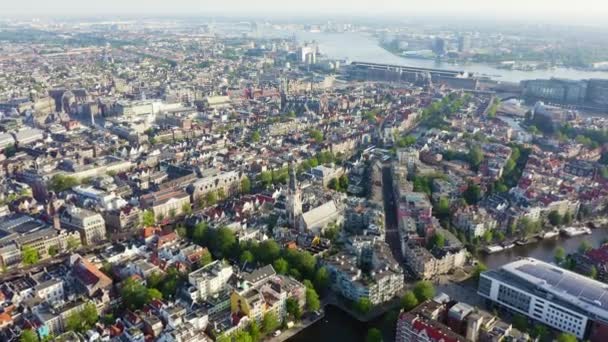 Amesterdão, Países Baixos. Voando sobre os telhados da cidade em direção à Estação Central de Amesterdão (Amsterdam Centraal). 4K — Vídeo de Stock
